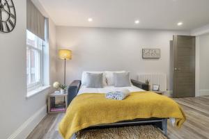 a bedroom with a bed with a yellow blanket at Boutique Living by Lawsons in Windsor