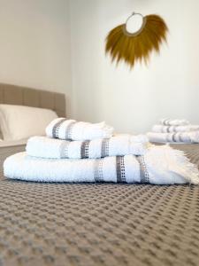 a stack of towels sitting on top of a bed at La Main Street suite in Andiparos