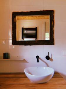 a bathroom with a bowl sink and a mirror at Domki u Danki in Brenna