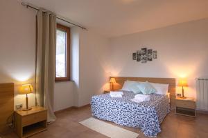 a bedroom with a bed with two lamps and a window at Hotel Locanda Minerva in Monteleone Rocca Doria