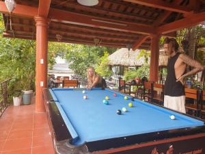 two people playing pool on a pool table at Cozy Son Hotel in Ninh Binh