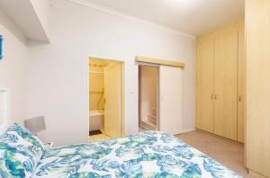 a bedroom with a bed with a blue and white blanket at Waters Breakaway in Bloubergstrand