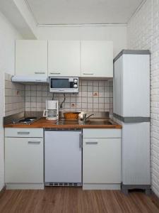 a kitchen with white cabinets and a sink and a microwave at Park Hotel in Konz