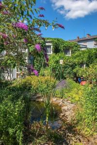 un jardín con flores púrpuras y un estanque en Park Hotel, en Konz