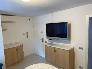 a room with a flat screen tv on the wall at San Pellegrino Solarium Apartment in San Pellegrino Terme