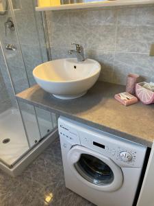 a bathroom with a sink and a washing machine at San Pellegrino Solarium Apartment in San Pellegrino Terme