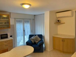 una sala de estar con una silla azul en la cocina en San Pellegrino Solarium Apartment, en San Pellegrino Terme
