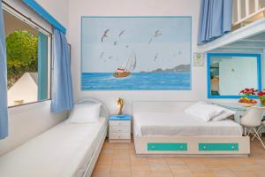 1 dormitorio con 2 camas y una ventana con un velero en Haraki Mare Studios beach front en Haraki