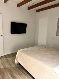 a bedroom with a bed and a flat screen tv on the wall at HOME TRES ESPERANZA a 2 cuadras de peatonal in Resistencia