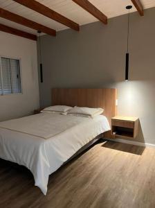 Un dormitorio con una gran cama blanca y una mesa en HOME TRES ESPERANZA a 2 cuadras de peatonal en Resistencia