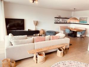 una sala de estar con un sofá y una mesa en Luxe appartement Cadzand-Bad, en Cadzand