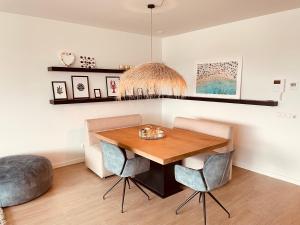 Un comedor con una mesa de madera y dos sillas. en Luxe appartement Cadzand-Bad, en Cadzand