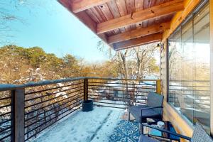 a balcony of a house with snow on the ground at Stay Happy in Eureka Springs