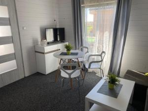 mały pokój ze stołem i telewizorem w obiekcie Domki na Łące w Sarbinowie