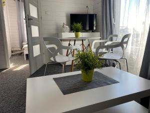 Domki na Łące في ساربينوفو: غرفة معيشة مع طاولة وكراسي بيضاء