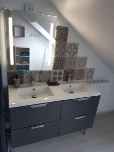 a bathroom with two sinks and a large mirror at Petit appartement à la campagne proche mer in Missillac