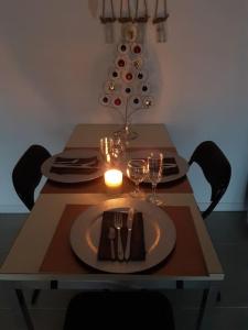 a dining room table with a christmas tree in the background at Petit appartement à la campagne proche mer in Missillac