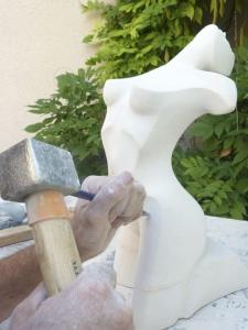 een man die met een hamer aan een sculptuur werkt bij Artist's Home - 65 m2 spacieux & confortable in Châlons-en-Champagne