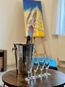 un groupe de verres à vin sur une table avec un seau dans l'établissement Artist's Home - 65 m2 spacieux & confortable, à Châlons-en-Champagne