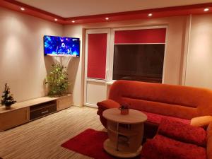 sala de estar con sofá y TV de pantalla plana en Trumpalaikė buto nuoma,apgyvendinimas - bekontaktis įėjimas en Rokiškis
