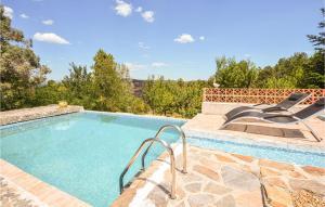 una piscina con una silla junto a ella en Awesome Home In Bordezac, en Bordezac