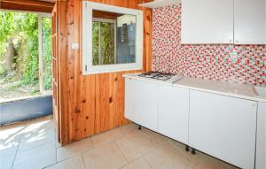 a kitchen with white cabinets and a stove top oven at Awesome Home In Bordezac With Outdoor Swimming Pool in Bordezac
