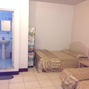 two beds in a room with a sink and a bathroom at Fudu Hotel in Dawu