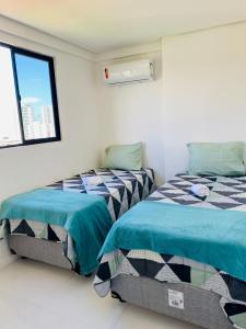 1 dormitorio con 2 camas y ventana en 2 quartos próximo a praia, en Maceió