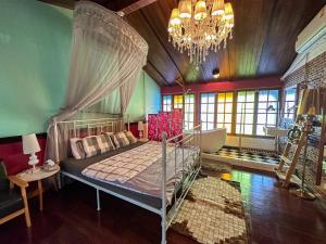 een slaapkamer met een hemelbed en een kroonluchter bij T-House BKK 2Floors near BTS with swimming pool and free Wifi in Klong Toi