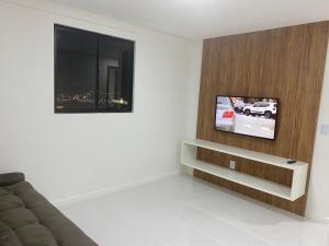 sala de estar con sofá y TV de pantalla plana en 2 quartos próximo a praia, en Maceió