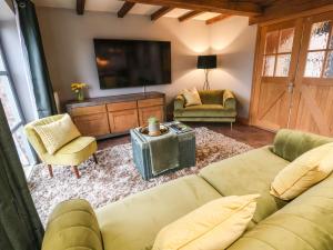 a living room with a couch and a tv at Oak Barn in Sandbach