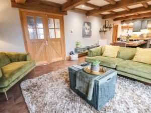 a living room with two couches and a table at Oak Barn in Sandbach