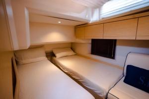 Habitación pequeña con 2 camas y ventana en Stella Romana Yacht en Dubái