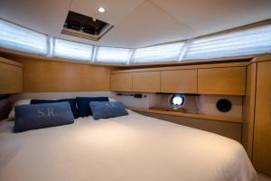 uma cama grande num barco com duas almofadas azuis em Stella Romana Yacht em Dubai