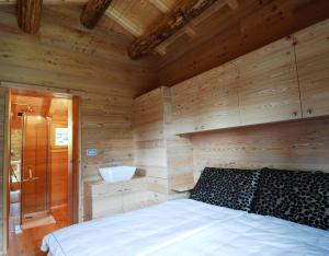 a bedroom with a bed and a bathroom with a sink at Chalet Nel Doch in Canale San Bovo +57 photos