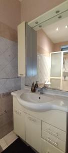 La salle de bains est pourvue d'un lavabo blanc et d'un miroir. dans l'établissement Pozzo Canale House, à Catane
