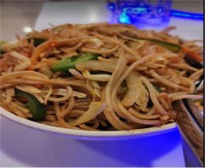 a bowl of food with noodles and green peppers at Gokul Raj By WB Economy , Madhubani in Madhubani