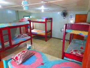 a dorm room with three bunk beds in it at Mana Lagoon Backpackers in Mana Island