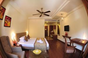 Habitación de hotel con cama y sala de estar. en Cambay Resort, Udaipur, en Udaipur