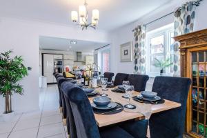 a dining room with a long table and chairs at Luxury detached home in 168 Upton Grange in Mollington