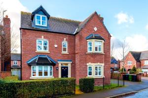 a red brick house with a black roof at Luxury detached home in 168 Upton Grange in Mollington