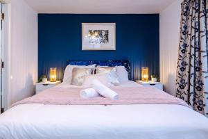 ein Schlafzimmer mit einem großen Bett mit blauen Wänden in der Unterkunft Luxury detached home in 168 Upton Grange in Mollington