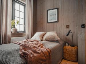 Tväråstugan في آرا: غرفة نوم بسرير وبطانية ونافذة