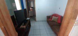 uma sala de estar com um sofá e uma televisão de ecrã plano em Casas de Aluguel da Lulu em Itapema