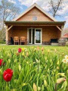 una casa con flores delante en Lodges near the Rhine - Sustainable Residence, en Hazerswoude-Rijndijk