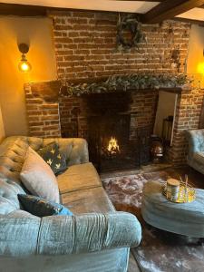 a living room with a couch and a fireplace at Arms Cottage in Bridge