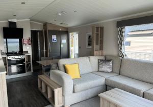 a living room with a couch and a kitchen at Braddicks Holidays - Sea View Apartments & Caravans in Westward Ho