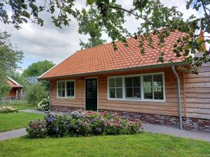 a small house with flowers in the yard at Lodges near the Rhine - Sustainable Residence in Hazerswoude-Rijndijk