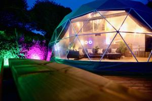 une maison igloo avec un canapé la nuit dans l'établissement Sunridge Geodome with private Hot tub, à Plymouth