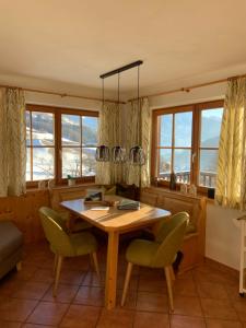 a dining room with a table and chairs and windows at Virgenhaus in Virgen